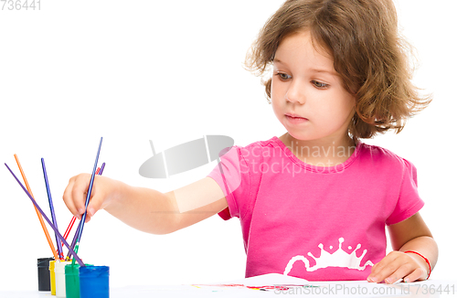 Image of Little girl is painting with gouache