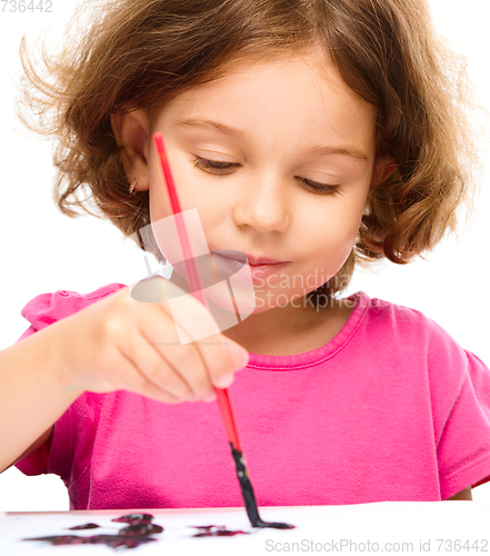 Image of Little girl is painting with gouache