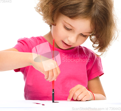 Image of Little girl is painting with gouache