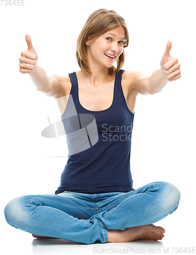 Image of Young happy woman is showing thumb up sign