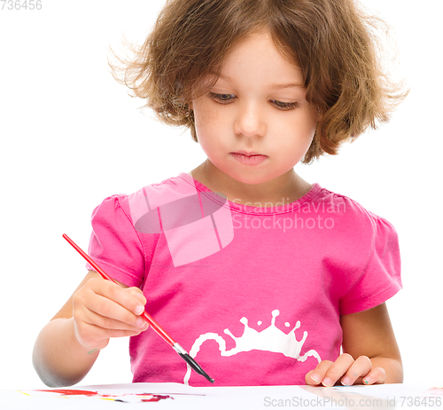 Image of Little girl is painting with gouache