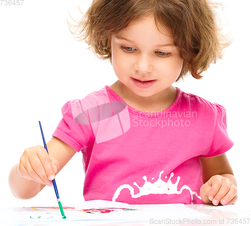 Image of Little girl is painting with gouache