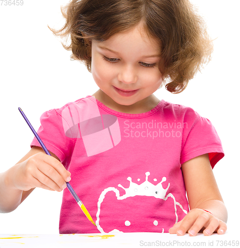 Image of Little girl is painting with gouache