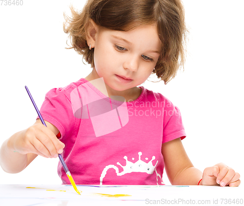 Image of Little girl is painting with gouache