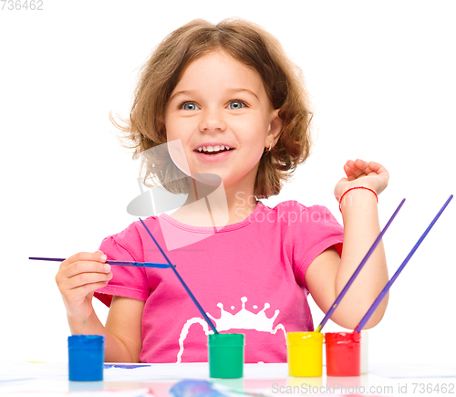 Image of Little girl is painting with gouache