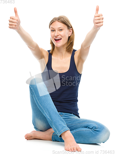 Image of Young happy woman is showing thumb up sign