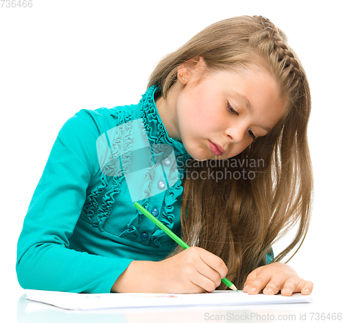 Image of Little girl is drawing using pencils