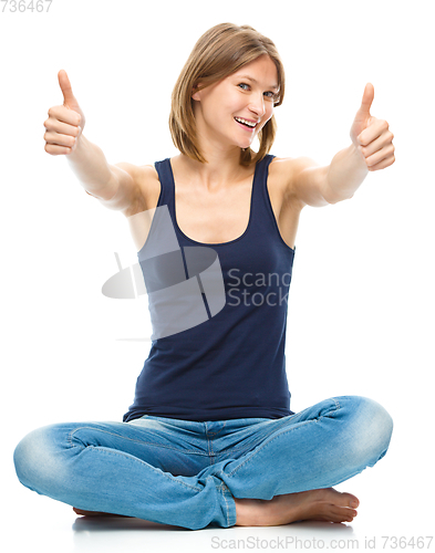 Image of Young happy woman is showing thumb up sign