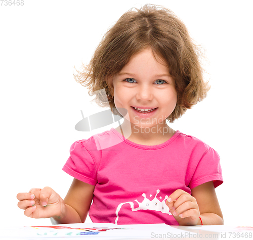 Image of Little girl is painting with gouache