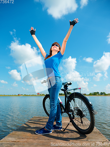 Image of Young woman raised her hands up in joy