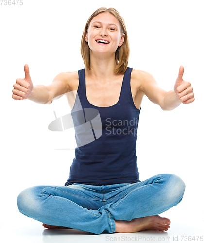 Image of Young happy woman is showing thumb up sign