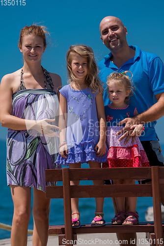 Image of portrait of young happy family with daughters by the sea