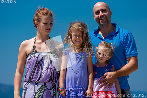 Image of portrait of young happy family with daughters by the sea