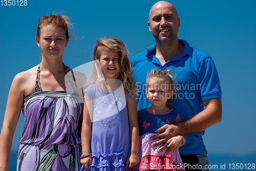 Image of portrait of young happy family with daughters by the sea