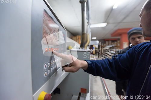 Image of carpenter calculating and programming a cnc wood working machine