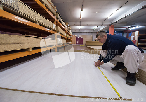 Image of carpenter measuring wooden board