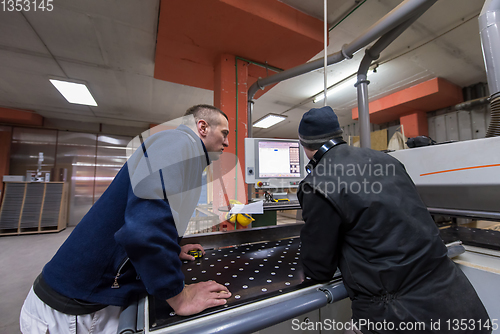 Image of carpenters calculating and programming a cnc wood working machin