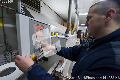 Image of carpenter calculating and programming a cnc wood working machine