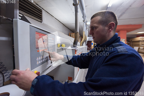 Image of carpenter calculating and programming a cnc wood working machine