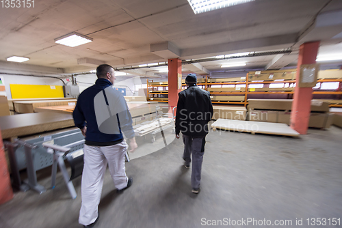 Image of two young carpenters working in big modern carpentry