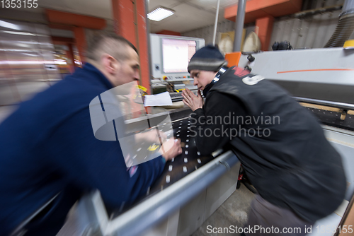 Image of carpenters calculating and programming a cnc wood working machin