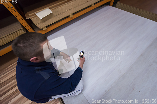 Image of carpenter using a mobile phone to calculate measures