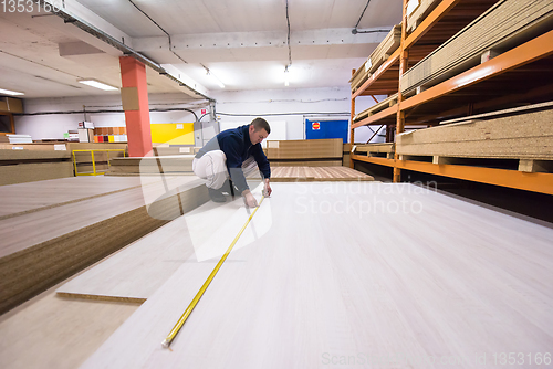 Image of carpenter measuring wooden board