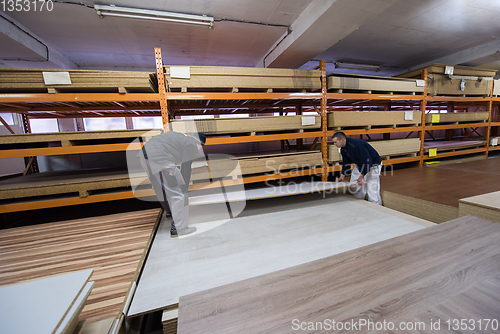 Image of two young carpenters working in big modern carpentry