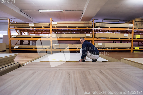 Image of carpenter measuring wooden board