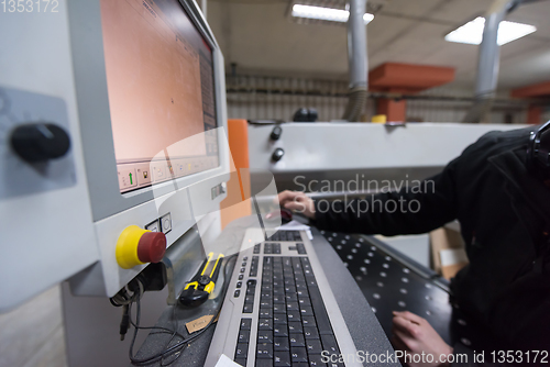 Image of carpenters calculating and programming a cnc wood working machin