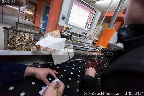 Image of carpenters calculating and programming a cnc wood working machin