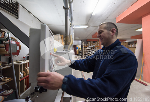 Image of carpenter calculating and programming a cnc wood working machine