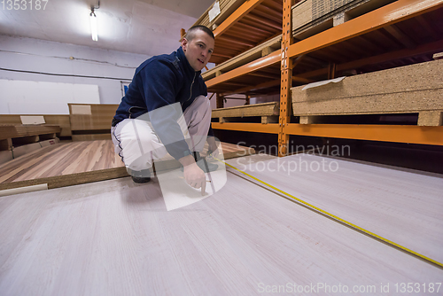 Image of carpenter measuring wooden board