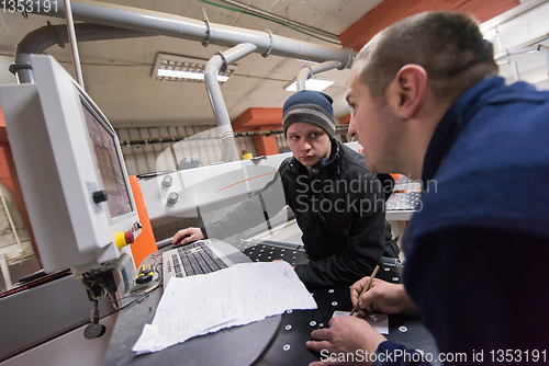 Image of carpenters calculating and programming a cnc wood working machin