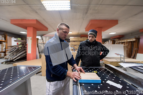 Image of carpenters calculating and programming a cnc wood working machin