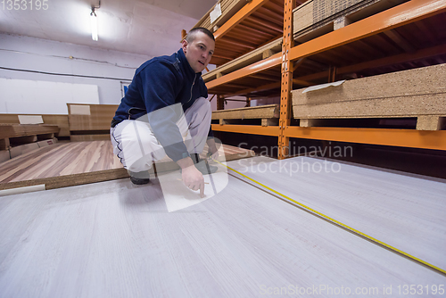 Image of carpenter measuring wooden board