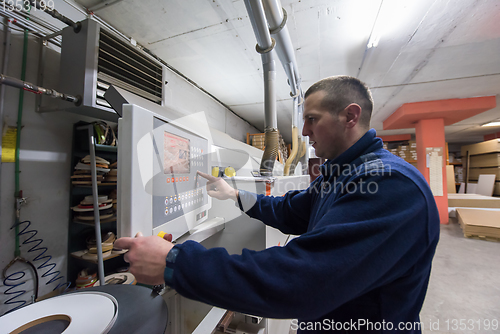 Image of carpenter calculating and programming a cnc wood working machine