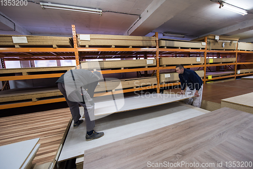 Image of two young carpenters working in big modern carpentry