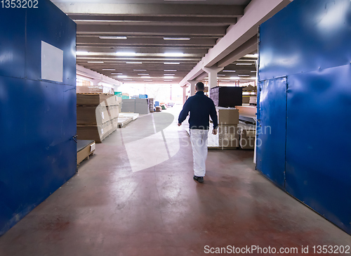 Image of carpenter walking through factory