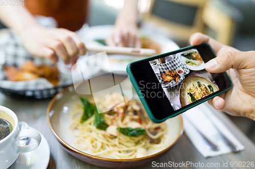 Image of Top view of people using mobile phone to take photo