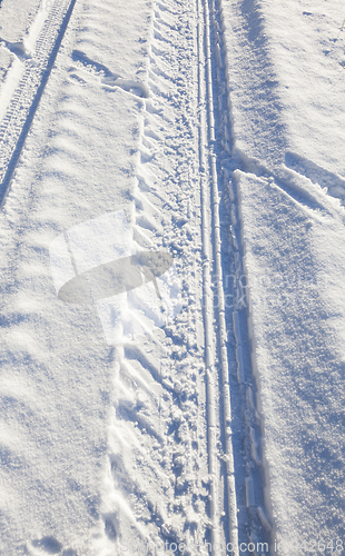 Image of trace of the car wheels on snow close-up