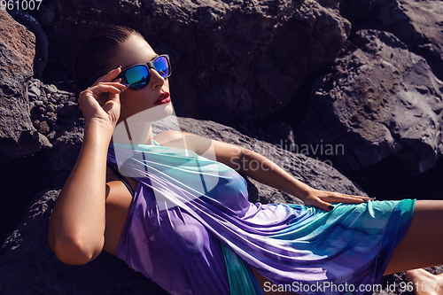 Image of beautiful girl on rocky shore