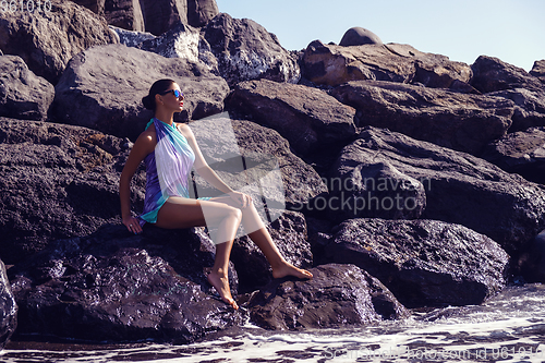 Image of beautiful girl on rocky shore