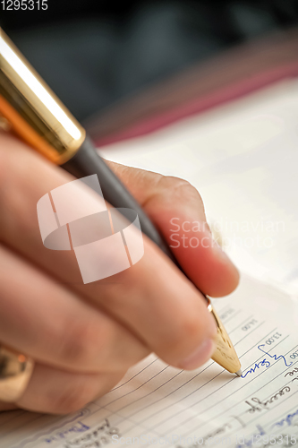 Image of Hand with pen when signing document.