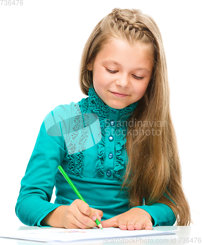 Image of Little girl is drawing using pencils