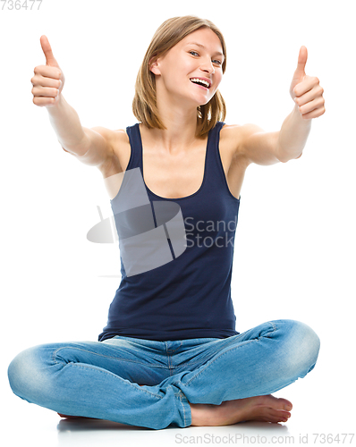 Image of Young happy woman is showing thumb up sign