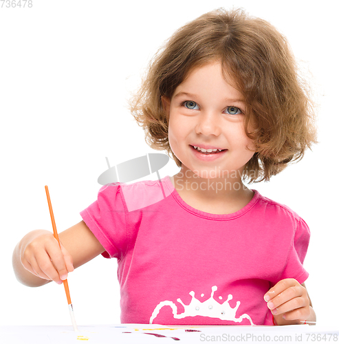 Image of Little girl is painting with gouache