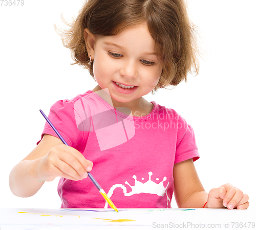 Image of Little girl is painting with gouache