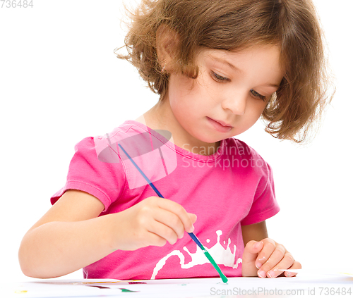 Image of Little girl is painting with gouache