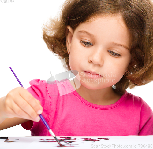 Image of Little girl is painting with gouache